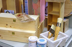 Verschiedene Holzboxen sowie Farben und Pinsel
