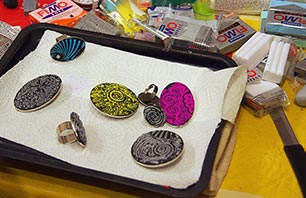 Ringe und Broschen mit bunten Ornamenten verziert